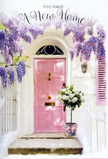 This doorway scene, likely somewhere in Watford's quieter residential streets, captures the feeling of stepping into a new chapter of life. At the heart is a beautifully painted pink door, its pastel tone gentle yet cheerful, set within simple whitewashed walls that provide a clean, bright backdrop. Above the door, wisteria pours down in lush cascades, each trailing cluster filled with small lavender and lilac blossoms that form a delicate floral canopy. The wisteria's soft, tumbling lines frame the entrance and cast gentle shadows, giving the façade a romantic, welcoming character that feels right at home near places like Nascot Wood or along the tree-lined avenues off St Albans Road. On the stone threshold, a grey metal bucket cradles a generous bouquet of white and cream roses. The roses are fully open and velvety, their petals unfolding in layered spirals that suggest freshness and expert arranging. Threads of soft green foliage weave among the blooms, adding contrast and a hint of movement. A pale pink ribbon is tied carefully around the bucket, its bow echoing the hue of the door and completing the soft pastel story. The light is natural and slightly warm, suggesting a calm afternoon when a housewarming delivery has just arrived and been set lovingly by the front step. The entire composition feels like a gentle embrace for someone moving into a new home in WD24 or nearby, a quiet but deeply felt message of congratulations, comfort, and welcome, spoken entirely through flowers, colour, and the promise of a door just waiting to be opened.